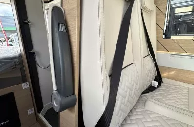 Siège de camping-car avec ceinture de sécurité et revêtement en cuir beige.