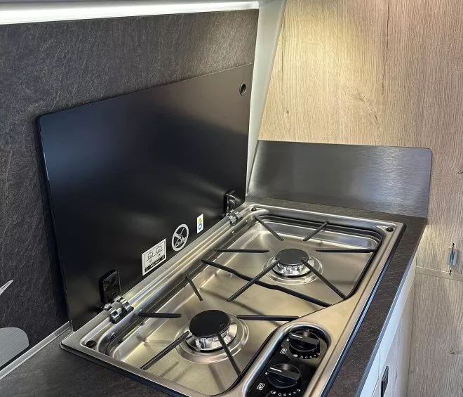 Plaque de cuisson à gaz intégrée dans une cuisine moderne avec plan de travail en bois.