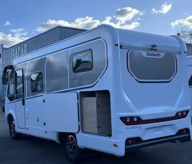 Camping-car Dethleffs Globebus GT stationné devant un bâtiment industriel
