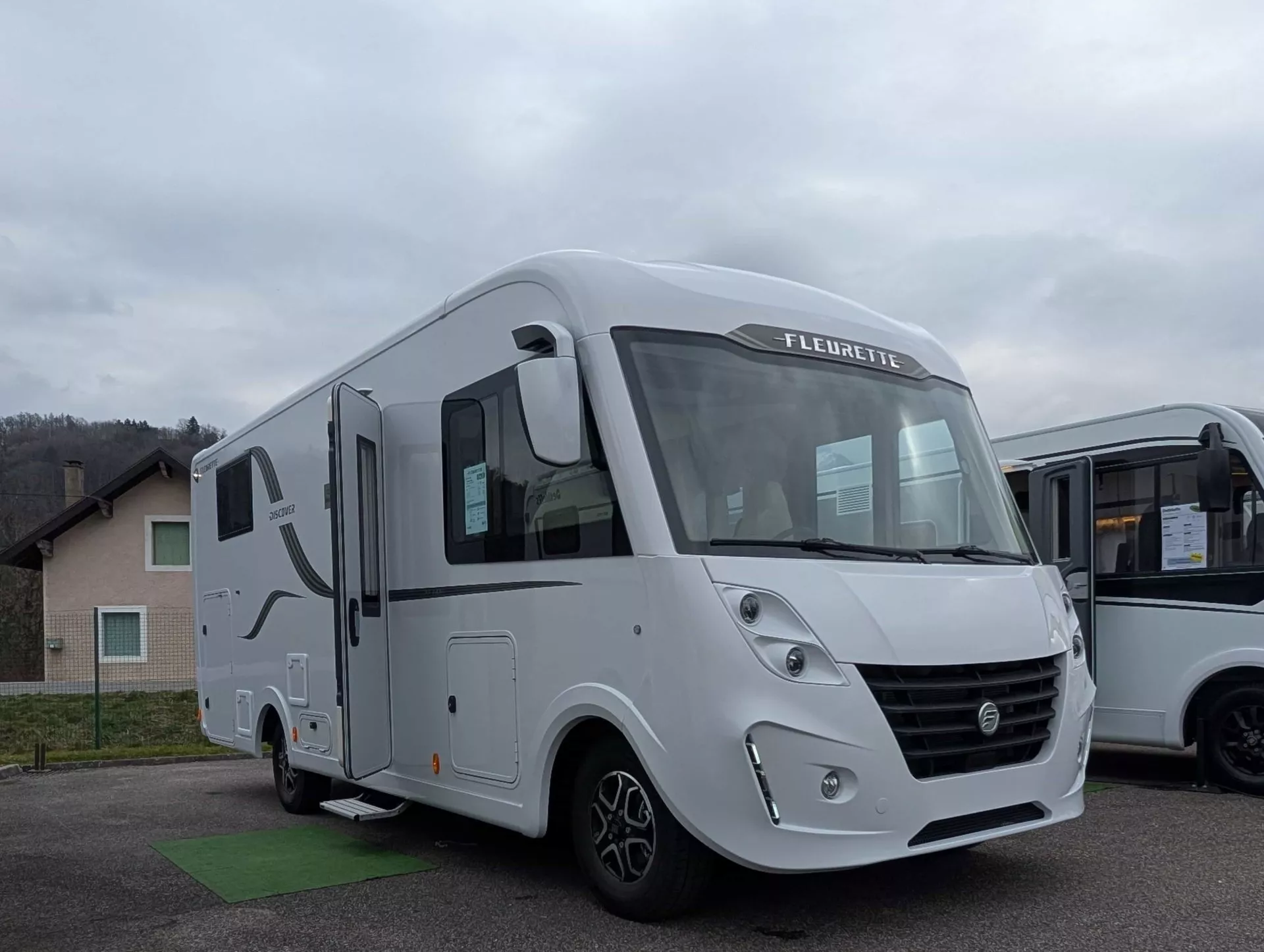 Camping-car Fleurette blanc stationné sur un parking