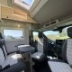 Intérieur d'un camping-car moderne avec sièges et table, vue sur la nature