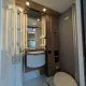 Salle de bain moderne dans un camping-car avec douche, lavabo et toilettes.