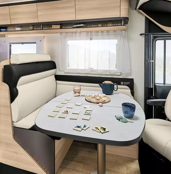 Intérieur d'un camping-car avec table dressée pour le thé et jeu de société.