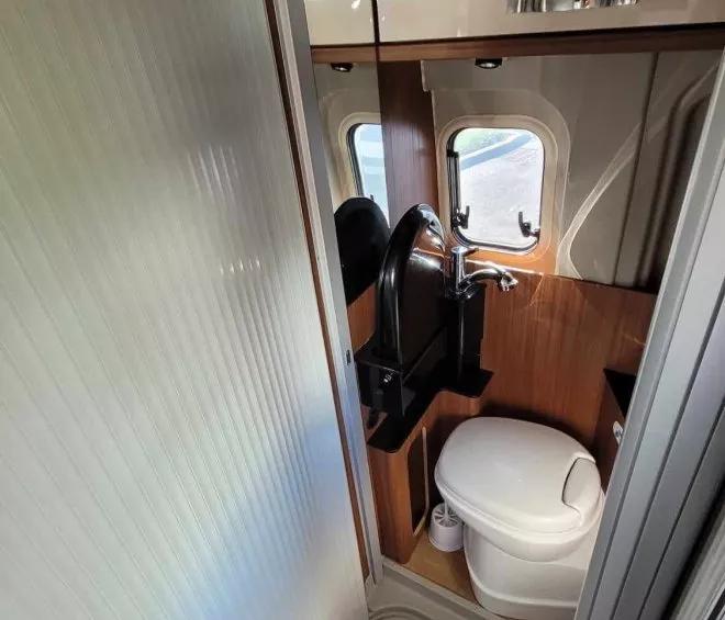 Salle de bain compacte dans un camping-car avec toilettes et lavabo