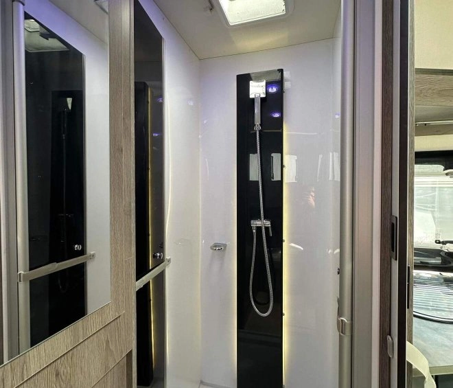 Douche moderne avec éclairage LED et parois en verre dans un espace compact.