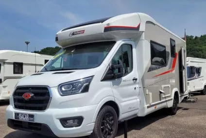 Camping-car Challenger stationné sur un parking sous un ciel bleu.