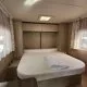 Intérieur d'une caravane avec lit double et rangements en bois clair
