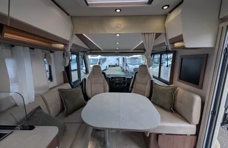 Intérieur d'un camping-car moderne avec table et sièges en cuir beige