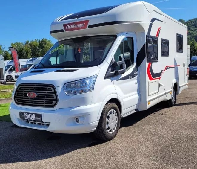 Camping-car Challenger blanc stationné sur un parking ensoleillé