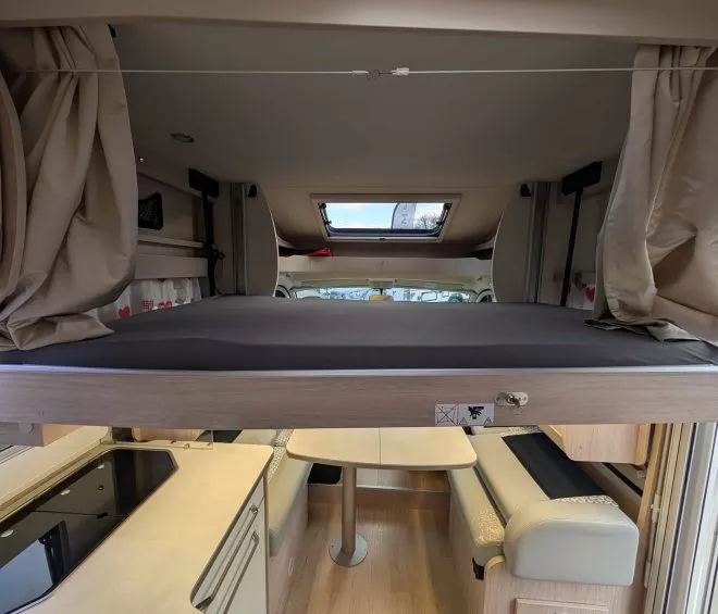 Intérieur d'un camping-car avec lit escamotable et coin cuisine moderne