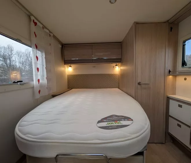 Intérieur d'une caravane avec lit double et éclairage doux