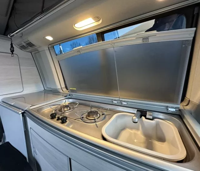 Cuisine équipée dans un van aménagé avec réchaud et évier