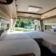 Intérieur d'un camping-car avec lit double et vue sur la route