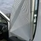 Store plissé blanc installé sur une fenêtre de véhicule utilitaire.