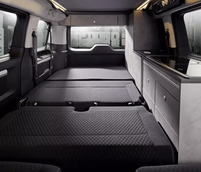 Intérieur d'un van aménagé avec lits et kitchenette moderne