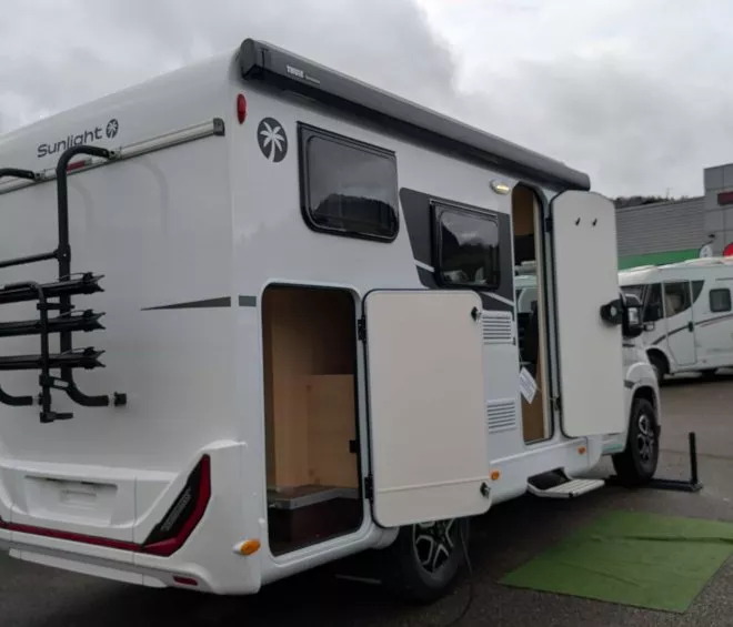 Camping-car Sunlight avec porte ouverte sur un parking de concessionnaire