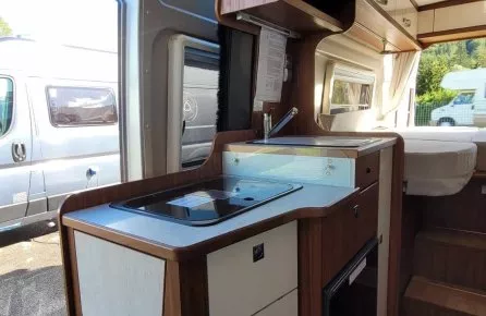 Intérieur d'un camping-car avec kitchenette et rangements en bois
