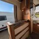 Intérieur d'un camping-car avec cuisine équipée et rangements en bois