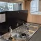 Cuisine intégrée avec plaques de cuisson et évier dans un camping-car moderne.
