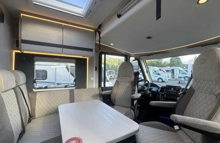 Intérieur d'un camping-car moderne avec sièges et table, éclairage LED