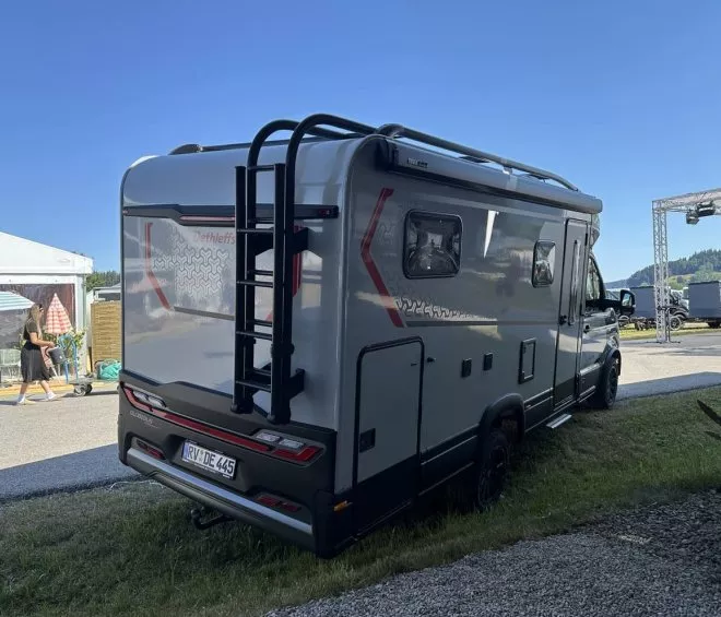 Camping-car Dethleffs stationné lors d'un événement en plein air, ciel dégagé
