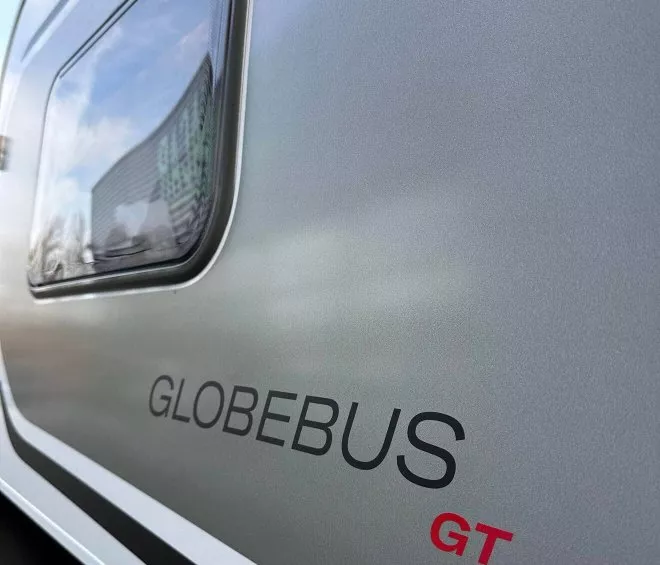 Vue latérale d'un camping-car Globebus GT avec fenêtre et logo visibles