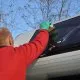 Nettoyage d'une fenêtre de caravane avec une éponge et des gants