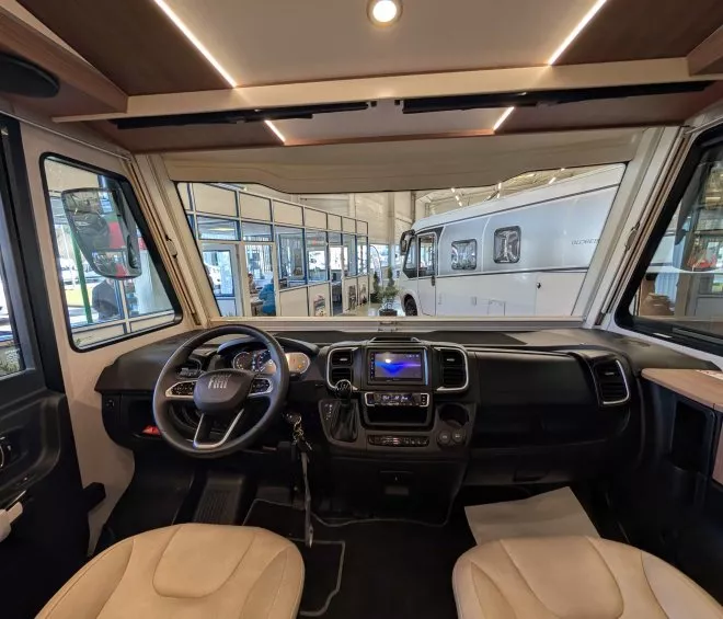 Intérieur d'un camping-car Fiat avec tableau de bord moderne et sièges en cuir beige