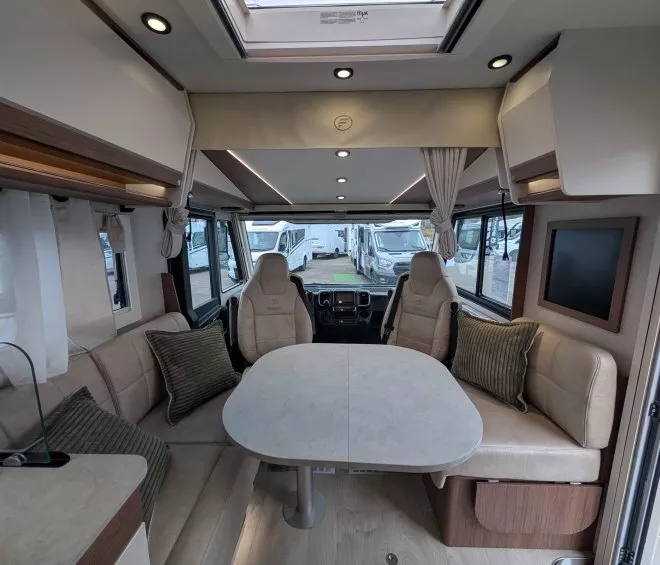 Intérieur d'un camping-car moderne avec table et sièges en cuir beige