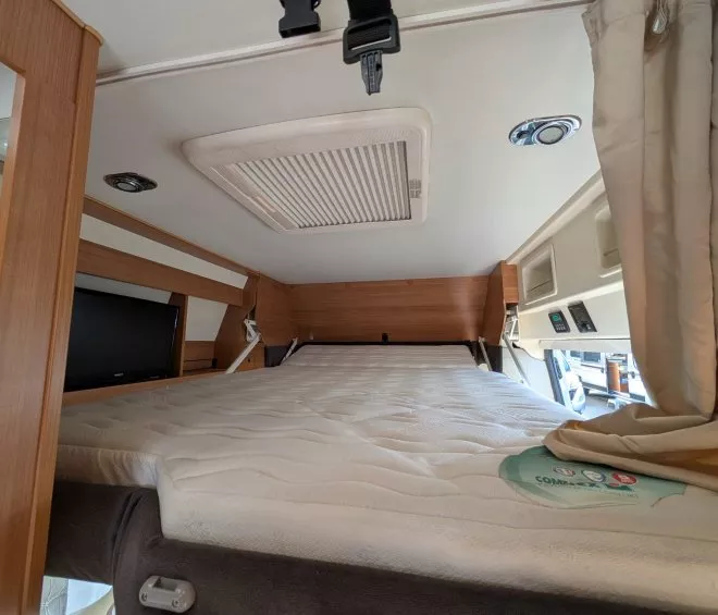 Intérieur d'un camping-car avec lit escamotable et éclairage intégré