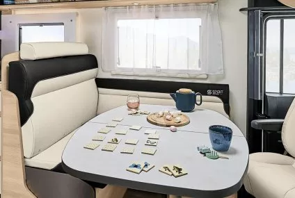 Intérieur d'un camping-car avec table dressée pour le thé et jeu de société.