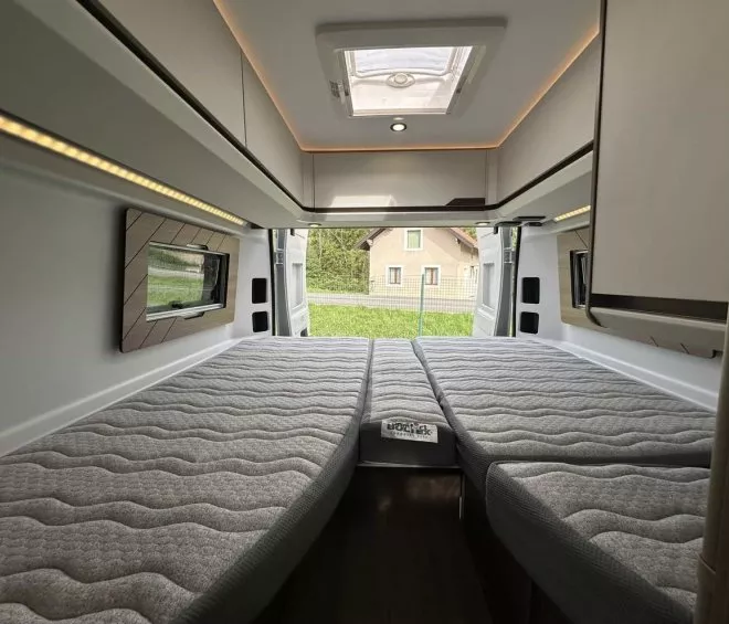 Intérieur d'un van aménagé avec lit double et éclairage LED