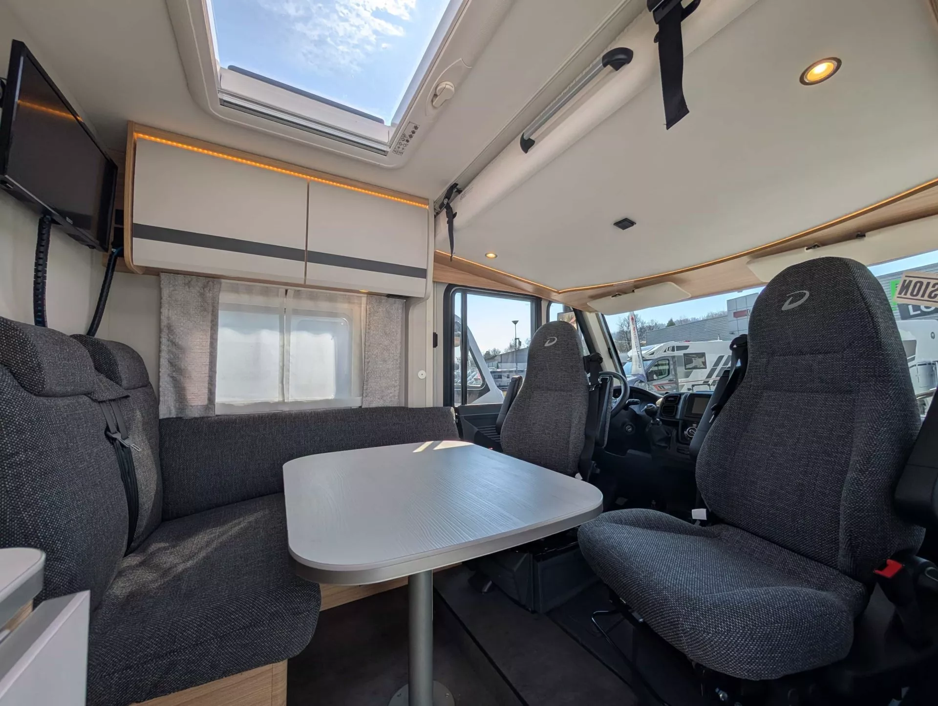 Intérieur d'un camping-car moderne avec table et sièges rembourrés