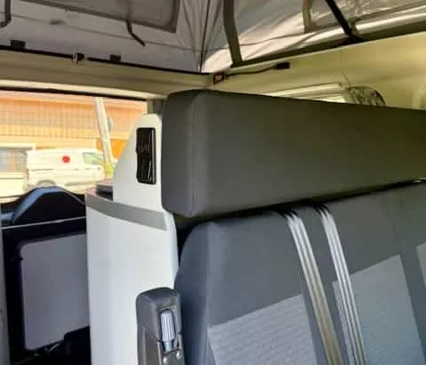 Intérieur d'un van aménagé avec sièges et espace de rangement