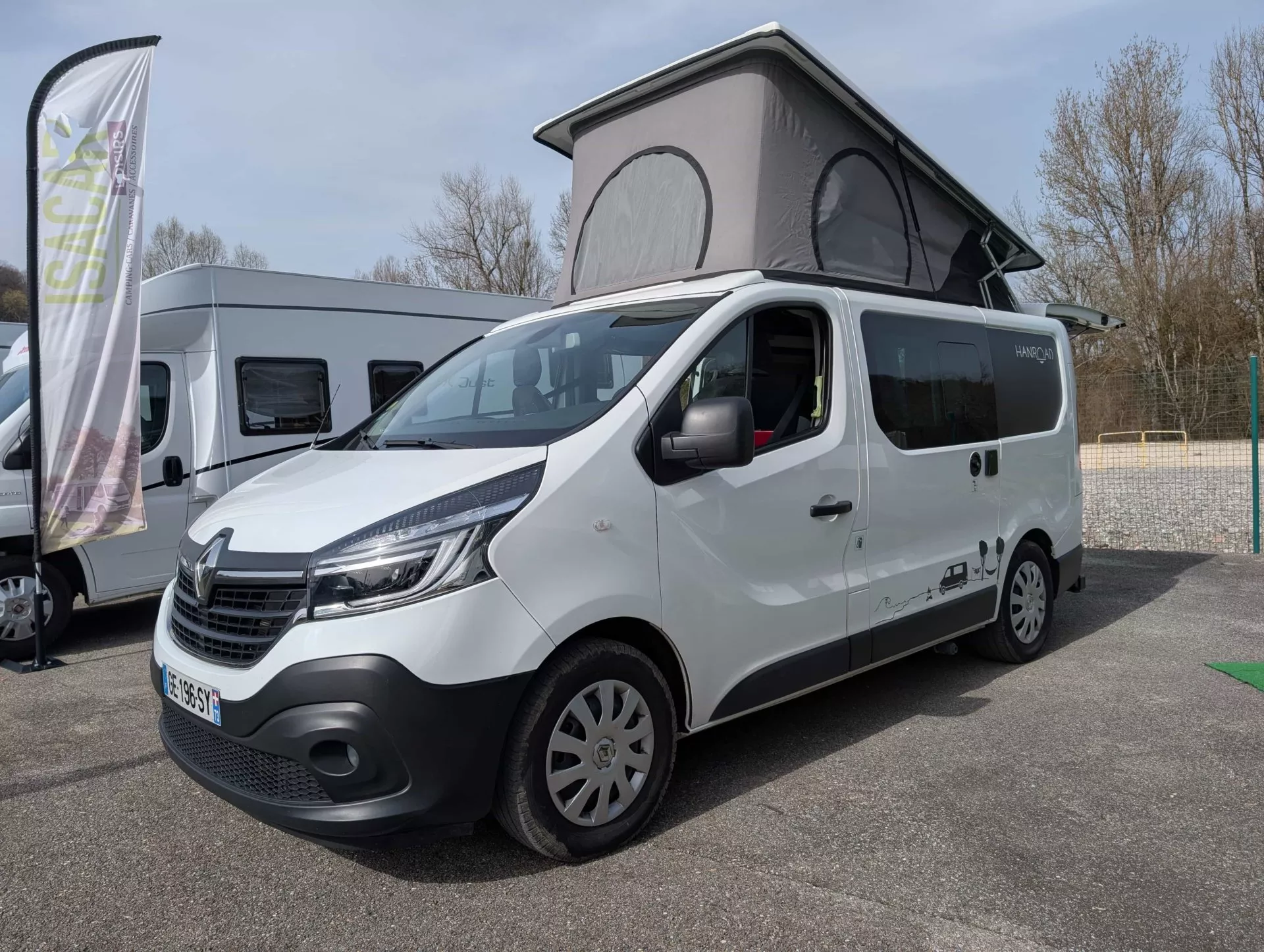 Van Renault aménagé avec toit relevable sur un parking
