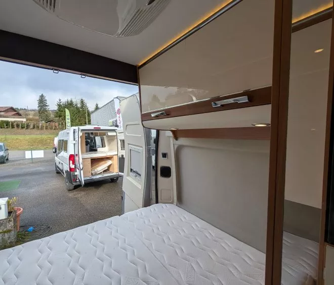 Intérieur d'un camping-car avec lit et rangements visibles