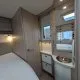 Intérieur d'une caravane avec lit, placard et lavabo moderne.