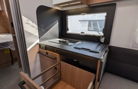 Cuisine compacte de camping-car avec tiroir ouvert et plaque de cuisson