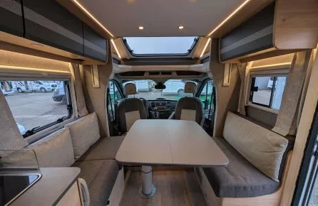 Intérieur d'un camping-car moderne avec table et banquettes grises