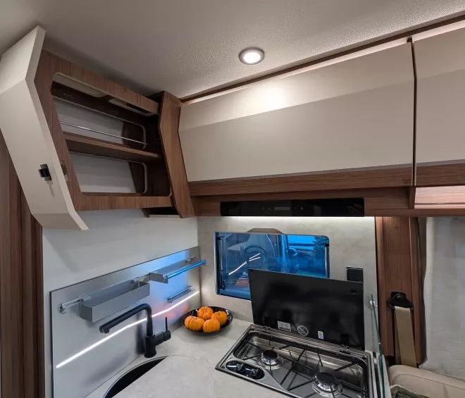 Cuisine compacte de camping-car avec évier, cuisinière et décoration citrouilles