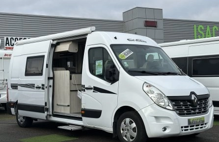 Camping-car Renault blanc stationné devant un concessionnaire