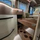 Intérieur d'un camping-car avec rangement en bois et sièges en cuir beige
