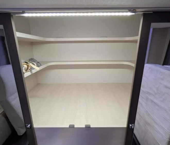Intérieur d'un camping-car avec espace de rangement et lit plié