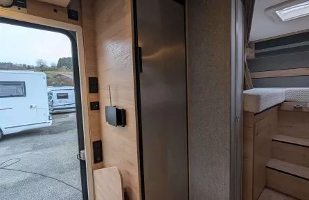 Intérieur d'un camping-car moderne avec mobilier en bois et réfrigérateur intégré