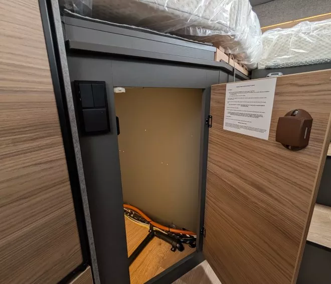 Armoire ouverte sous un lit avec rangement pour vélo pliant