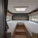 Intérieur d'une caravane avec deux lits simples et fenêtres latérales