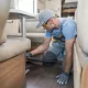 Technicien nettoyant l'intérieur d'un camping-car avec un aspirateur