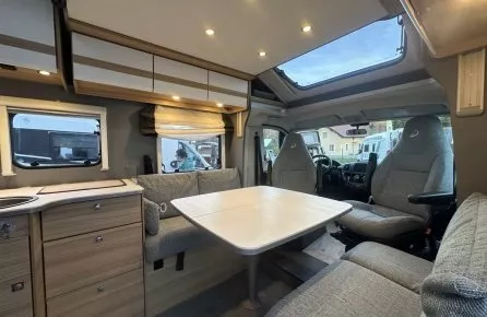 Intérieur d'un camping-car moderne avec table et sièges en tissu gris