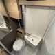 Salle de bain compacte avec lavabo et toilettes dans un camping-car moderne.