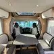 Intérieur d'un camping-car moderne avec table et sièges en cuir gris.